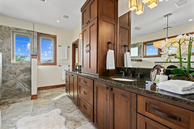 21216 Bertram Ln, Spicewood, TX 78669 - bathroom with vanity, a walk in shower, and baseboards