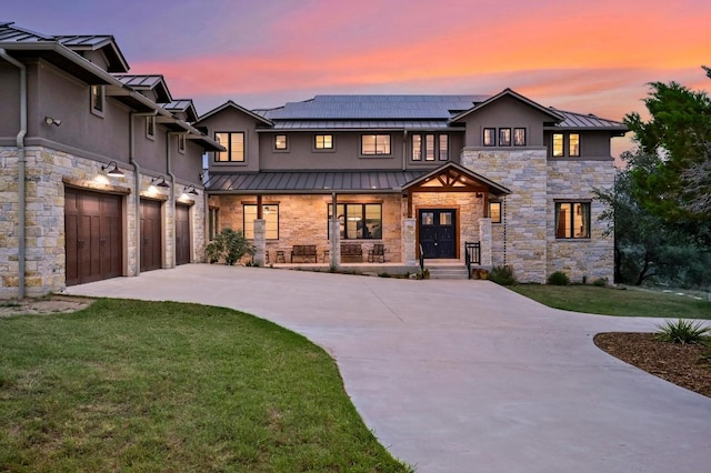 21216 Bertram Ln, Spicewood, TX 78669 - view of front of home featuring a standing seam roof, stone siding, driveway, metal roof, and covered porch
