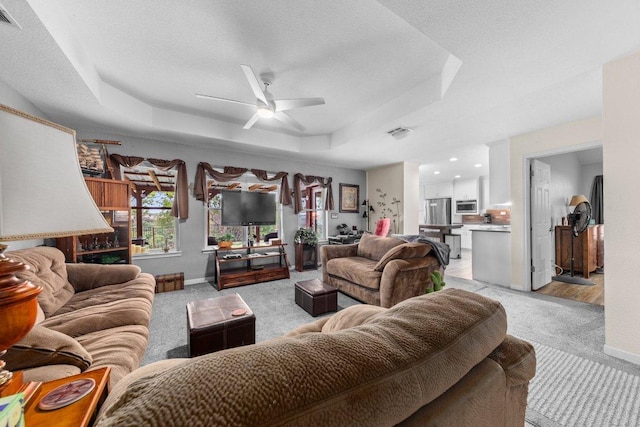 5315 Denmans Loop, Belton, TX 76513 - living area with a tray ceiling, baseboards, ceiling fan, visible vents, and light colored carpet