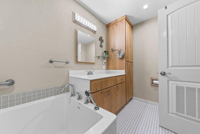 5315 Denmans Loop, Belton, TX 76513 - bathroom featuring baseboards, visible vents, a bath, tile patterned floors, and a textured wall