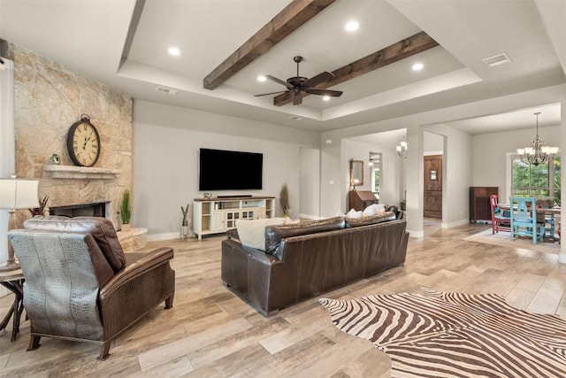 413 Creekside Dr, Salado, TX 76571 - living room with a tray ceiling, light wood finished floors, ceiling fan with notable chandelier, and baseboards