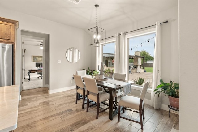 413 Creekside Dr, Salado, TX 76571 - dining area with light wood finished floors, ceiling fan with notable chandelier, baseboards, and visible vents