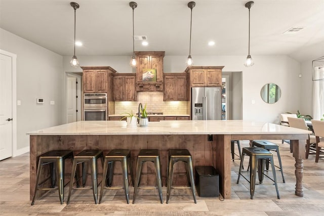 413 Creekside Dr, Salado, TX 76571 - kitchen featuring stainless steel appliances, tasteful backsplash, visible vents, and light wood-style flooring