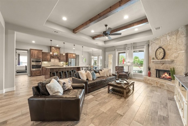 413 Creekside Dr, Salado, TX 76571 - living area featuring light wood-type flooring, a stone fireplace, visible vents, and a ceiling fan