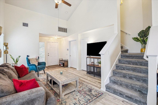 living room featuring visible vents, wood finished floors, a ceiling fan, and stairway