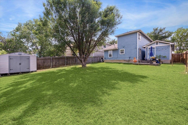 view of yard featuring an outbuilding, a fenced backyard, and a shed