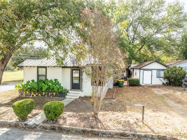 1226 Saint Matthew St, Gonzales, TX 78629 - single story home with metal roof, an outdoor structure, concrete block siding, entry steps, and a storage shed