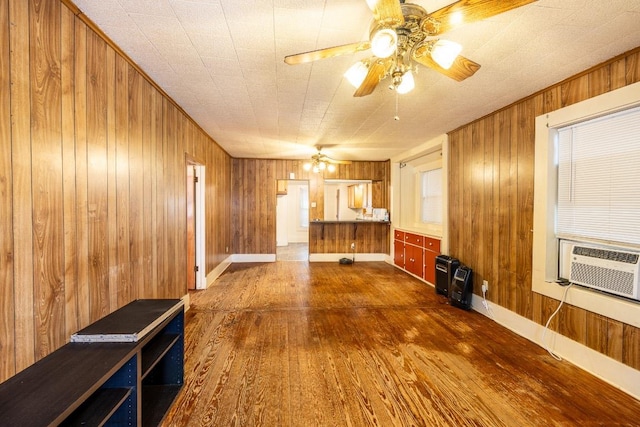 1226 Saint Matthew St, Gonzales, TX 78629 - unfurnished living room with heating unit, a ceiling fan, cooling unit, wood walls, and dark wood-style flooring