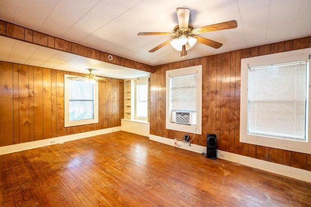 1226 Saint Matthew St, Gonzales, TX 78629 - empty room with wood walls, a ceiling fan, and wood-type flooring