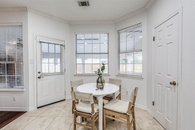 dining area with light tile patterned floors, visible vents, baseboards, and ornamental molding
