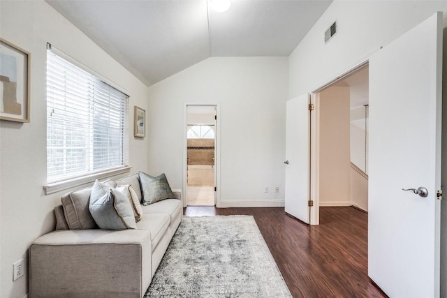 living area with vaulted ceiling, baseboards, visible vents, and dark wood-type flooring