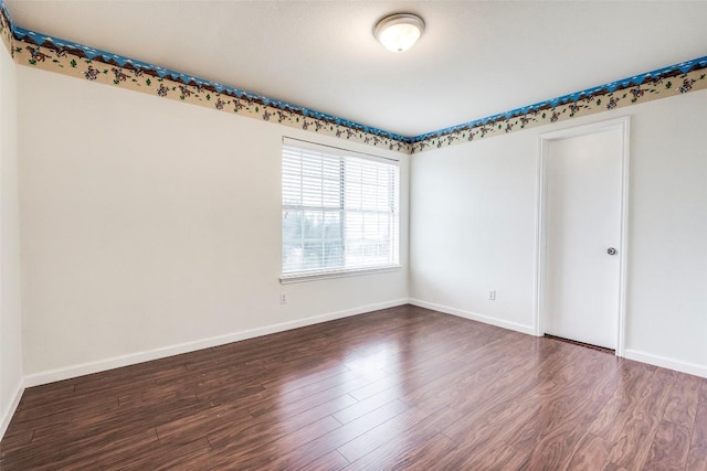 empty room featuring wood finished floors and baseboards