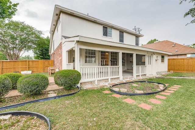 back of house with a lawn and a fenced backyard
