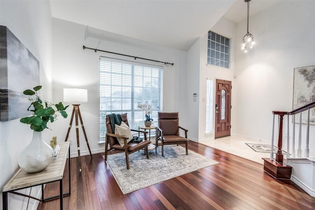 entrance foyer featuring a high ceiling, stairway, baseboards, and wood-type flooring