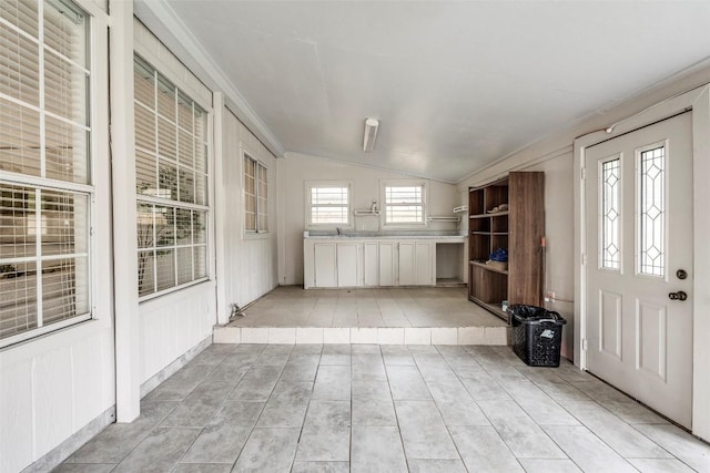 interior space featuring vaulted ceiling and crown molding