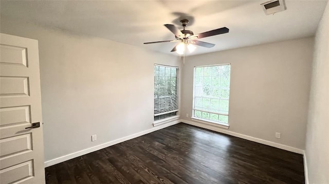 unfurnished room with baseboards, a ceiling fan, dark wood-type flooring, and visible vents