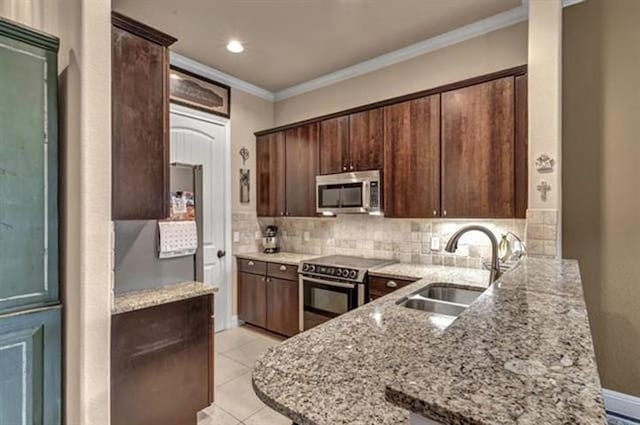 kitchen featuring a sink, a peninsula, crown molding, stainless steel appliances, and tasteful backsplash
