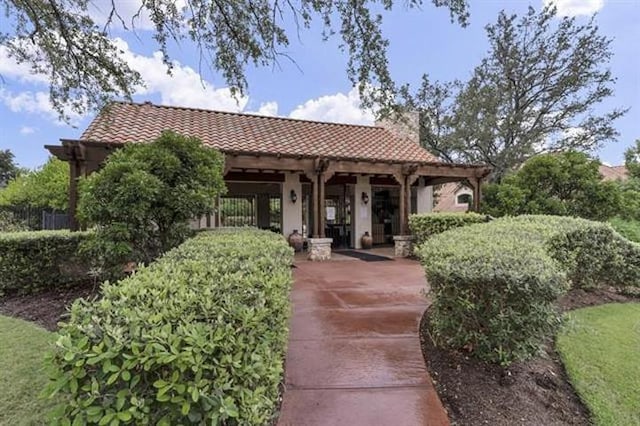 exterior space featuring a chimney and a tile roof