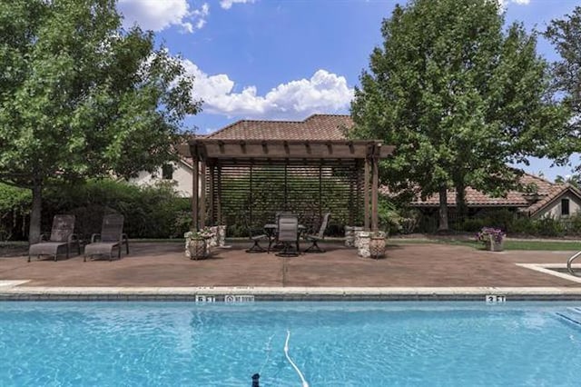 pool with a patio area and a pergola