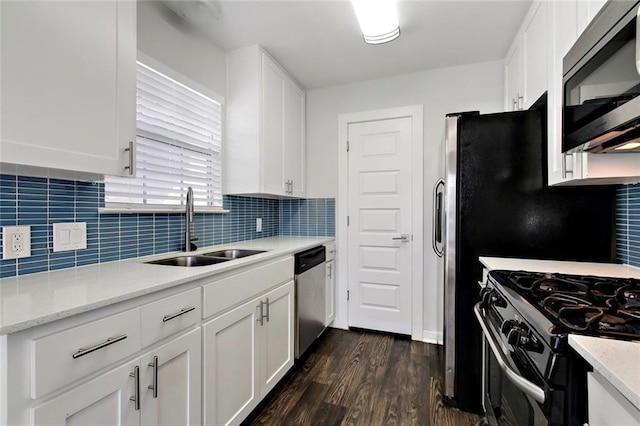 kitchen featuring a sink, white cabinets, dark wood-style floors, and appliances with stainless steel finishes