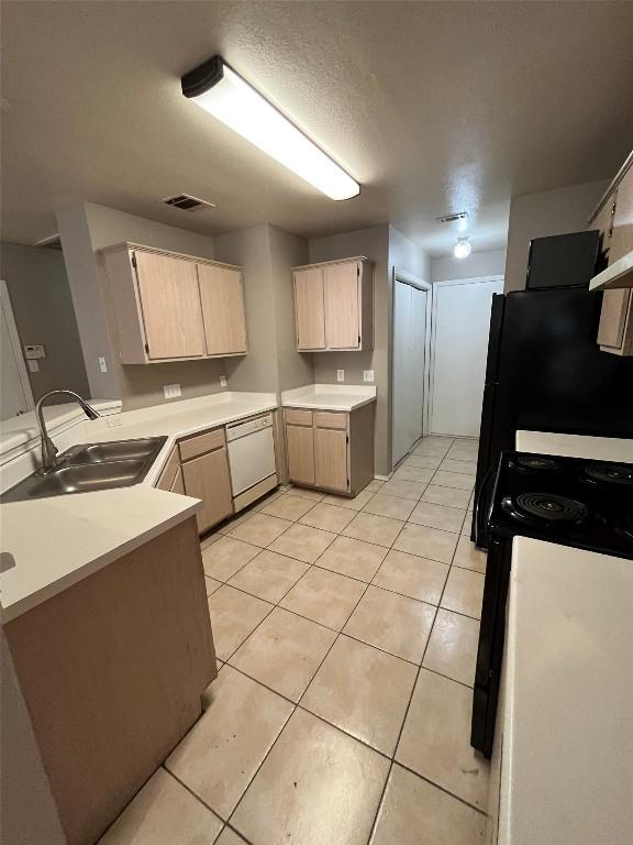 9625 Sugar Hill Dr, Austin, TX 78748 - kitchen with light tile patterned floors, light brown cabinets, a sink, and dishwasher