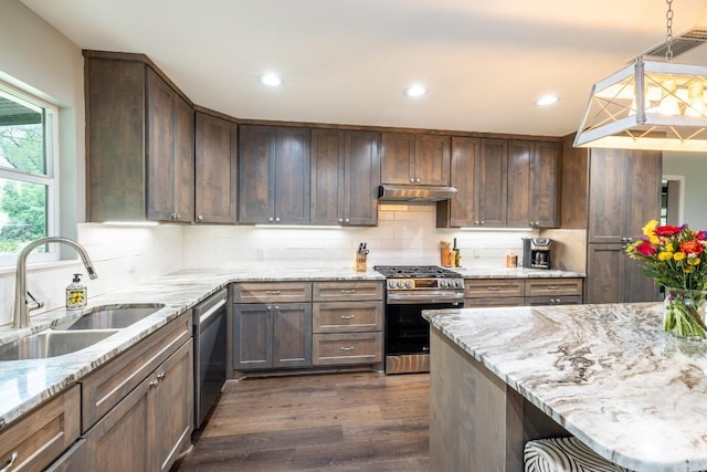 1318 Neuman St, Gonzales, TX 78629 - kitchen with appliances with stainless steel finishes, under cabinet range hood, a sink, dark wood-style flooring, and decorative backsplash