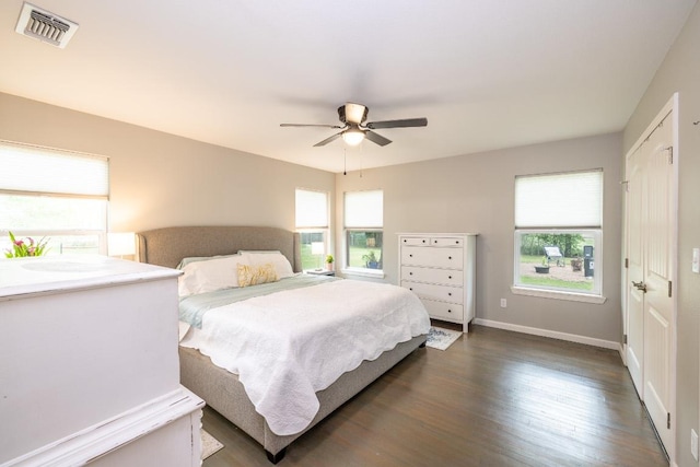 1318 Neuman St, Gonzales, TX 78629 - bedroom with multiple windows, dark wood-type flooring, baseboards, and ceiling fan