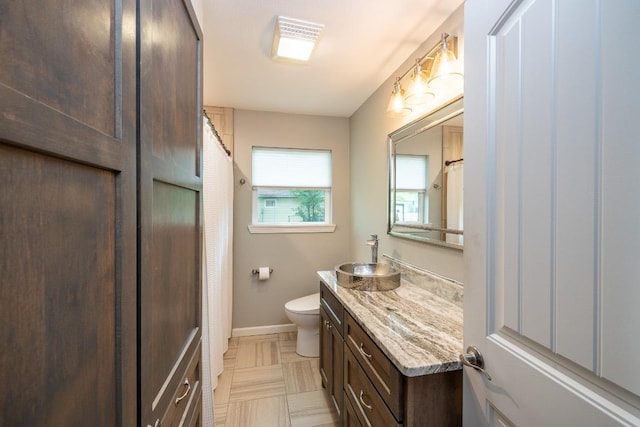 1318 Neuman St, Gonzales, TX 78629 - bathroom with toilet, vanity, baseboards, and a shower with curtain