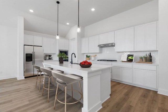 1108 Snowdrop Dr, Georgetown, TX 78628 - kitchen with stainless steel appliances, tasteful backsplash, white cabinetry, a kitchen breakfast bar, and vaulted ceiling