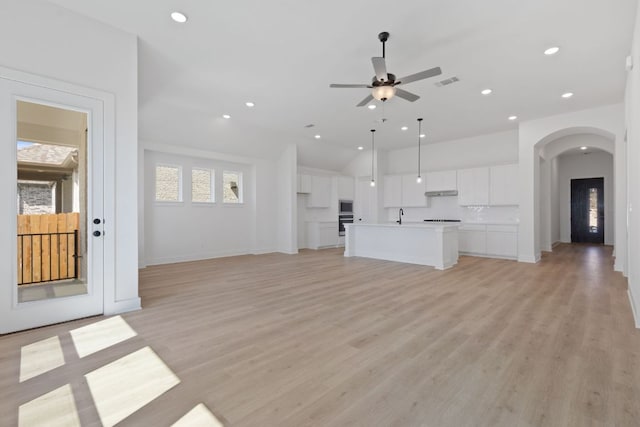 1108 Snowdrop Dr, Georgetown, TX 78628 - unfurnished living room featuring arched walkways, a ceiling fan, recessed lighting, and light wood-type flooring