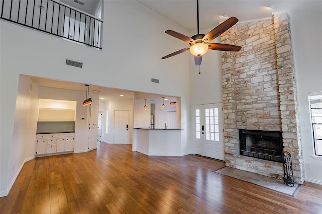 unfurnished living room featuring visible vents, wood finished floors, and ceiling fan