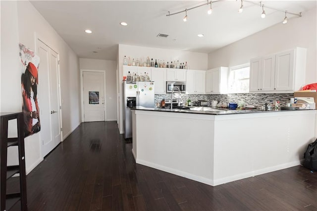 kitchen featuring stainless steel appliances, backsplash, visible vents, and dark wood finished floors