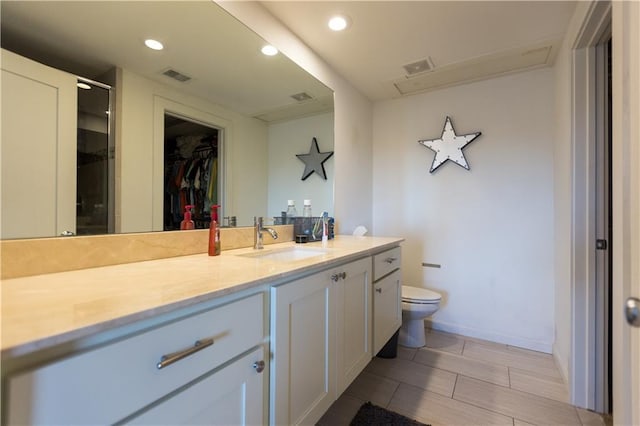 bathroom with vanity, toilet, visible vents, and recessed lighting