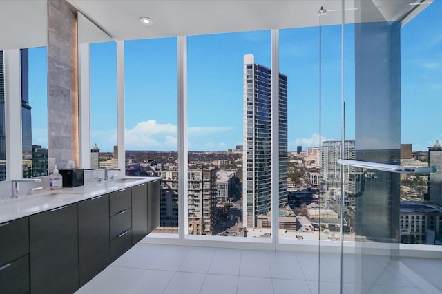 interior space featuring a sink, tile patterned floors, a city view, floor to ceiling windows, and double vanity