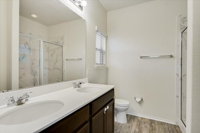 201 Cascata Way, Liberty Hill, TX 78642 - bathroom featuring toilet, a marble finish shower, double vanity, wood finished floors, and baseboards
