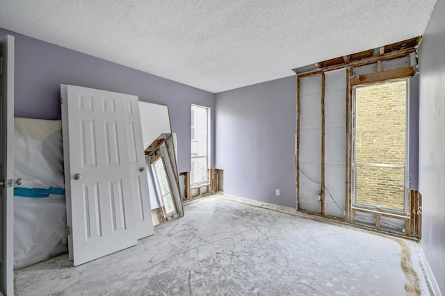 unfurnished room featuring a textured ceiling