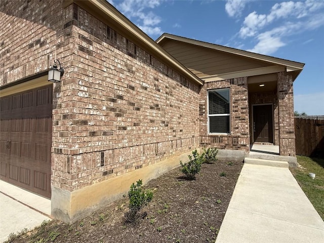 4482 Acerno St, Round Rock, TX 78665 - property entrance with an attached garage, brick siding, and driveway