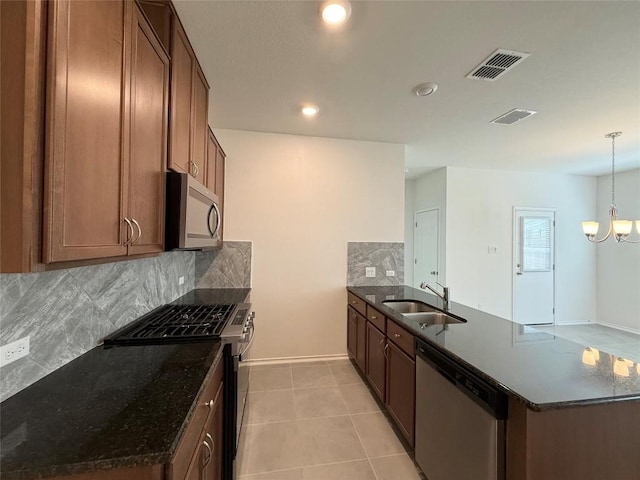 4482 Acerno St, Round Rock, TX 78665 - kitchen with appliances with stainless steel finishes, a peninsula, tasteful backsplash, dark stone counters, and recessed lighting