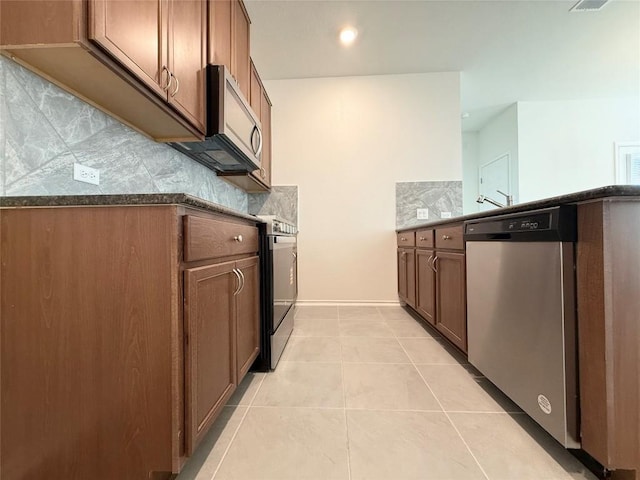 4482 Acerno St, Round Rock, TX 78665 - kitchen with stainless steel appliances, decorative backsplash, light tile patterned flooring, dark stone counters, and recessed lighting