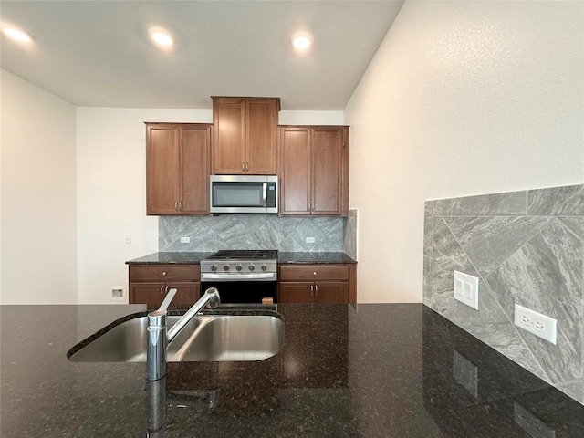 4482 Acerno St, Round Rock, TX 78665 - kitchen featuring stainless steel appliances, dark stone counters, decorative backsplash, and brown cabinets