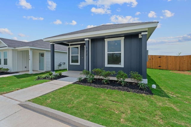 127 Safflower Dr, Uhland, TX 78640 - ranch-style home with a front lawn, board and batten siding, a porch, and fence