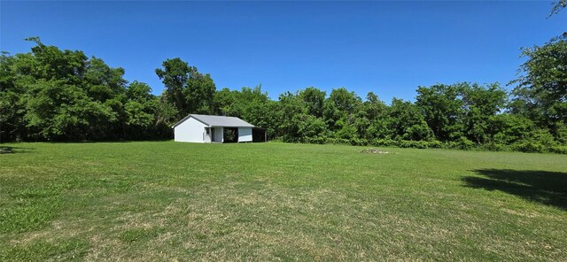 8660 Cedar Hill Rd, Brenham, TX 77833 - view of grassy yard featuring an outdoor structure and a view of trees