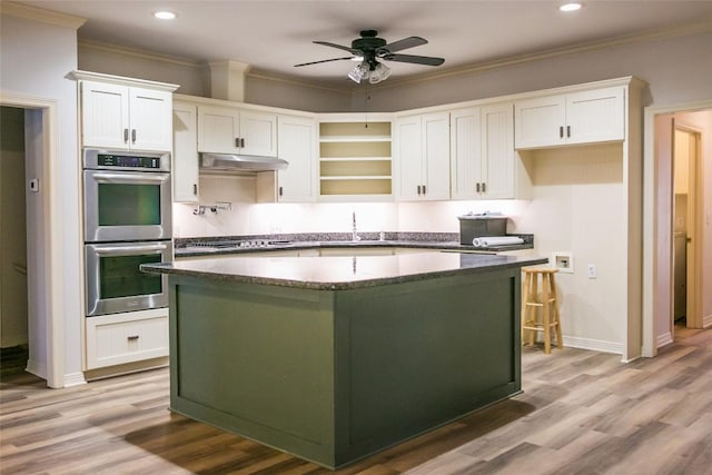 8660 Cedar Hill Rd, Brenham, TX 77833 - kitchen with stainless steel double oven, white cabinets, ceiling fan, a center island, and recessed lighting
