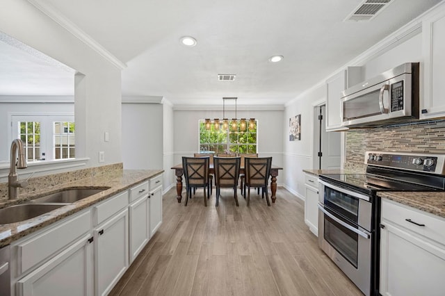 905 Whispering Hollow Dr, Kyle, TX 78640 - kitchen featuring appliances with stainless steel finishes, visible vents, a healthy amount of sunlight, and a sink