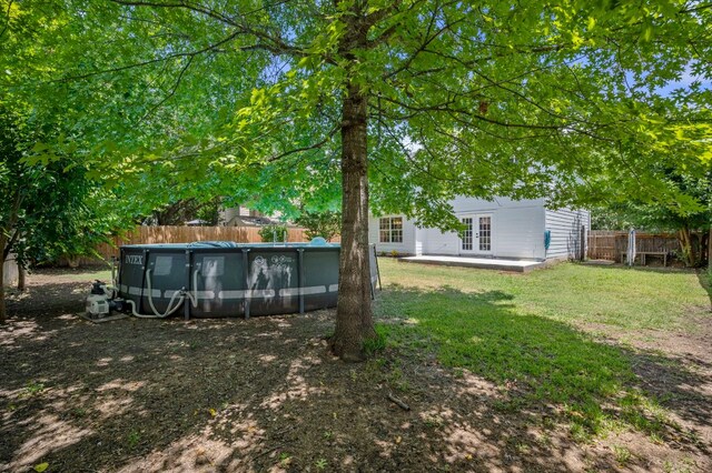 905 Whispering Hollow Dr, Kyle, TX 78640 - view of yard with an outdoor pool, french doors, and a fenced backyard