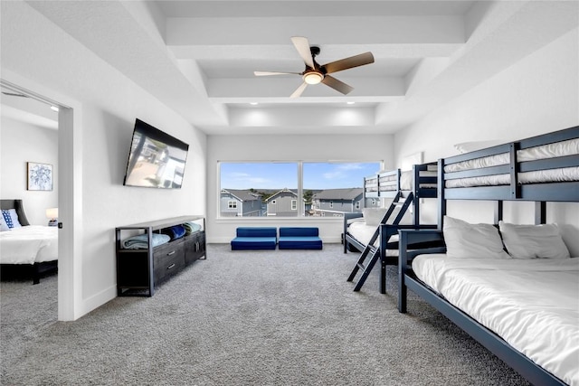 carpeted bedroom with a tray ceiling, ceiling fan, and baseboards
