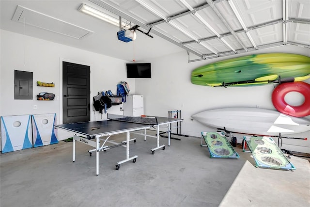 garage featuring electric panel, a garage door opener, and freestanding refrigerator