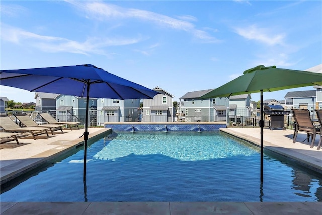 pool featuring fence, a patio, area for grilling, and a residential view