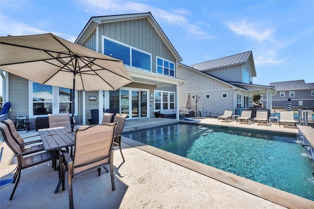 pool with a patio area and fence