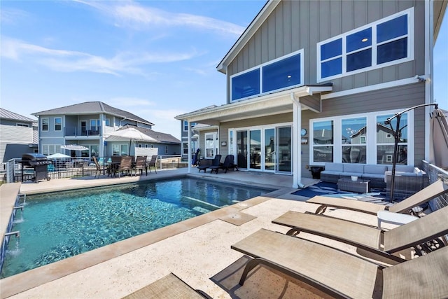 outdoor pool featuring a patio area, a grill, and an outdoor living space